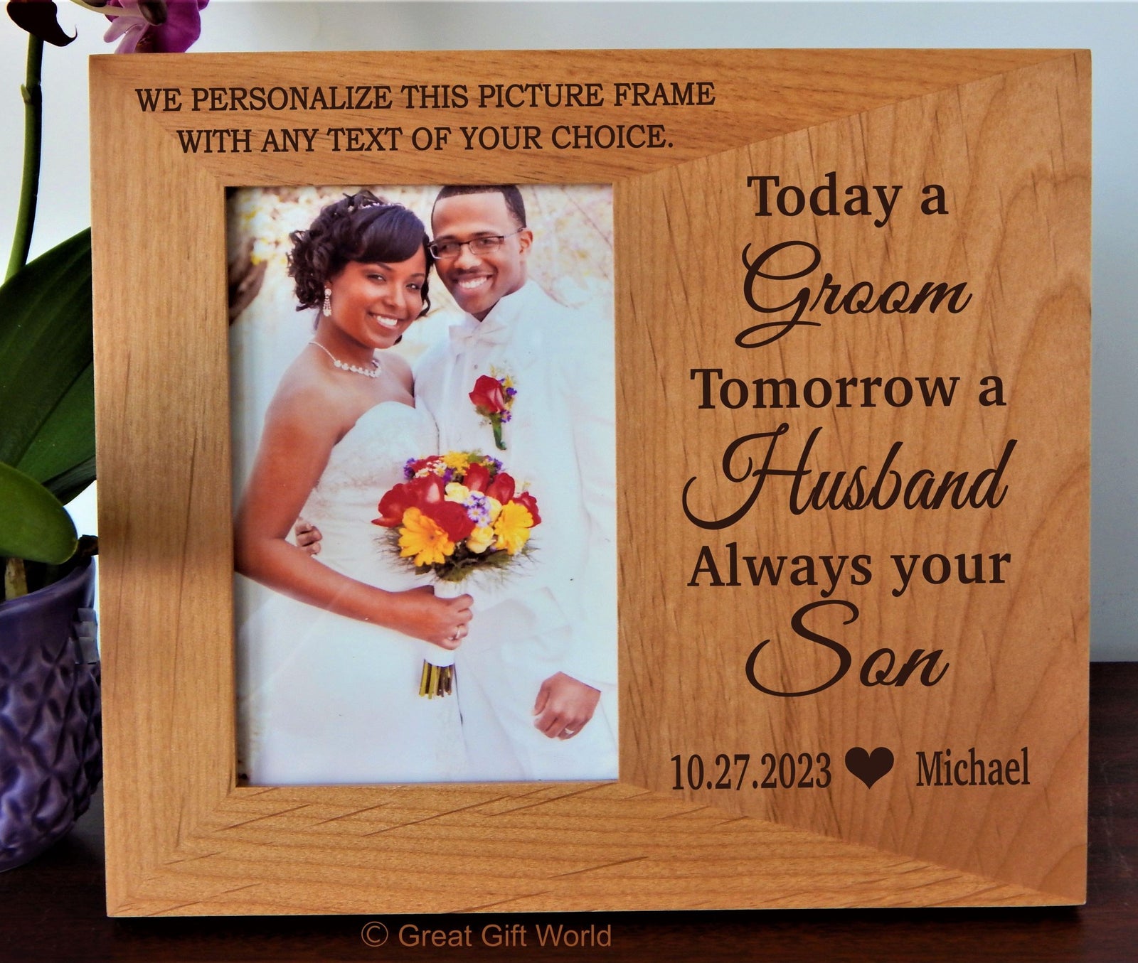 A personalized wooden photo frame with an engraved couple's picture and textual decoration, displayed on a table.