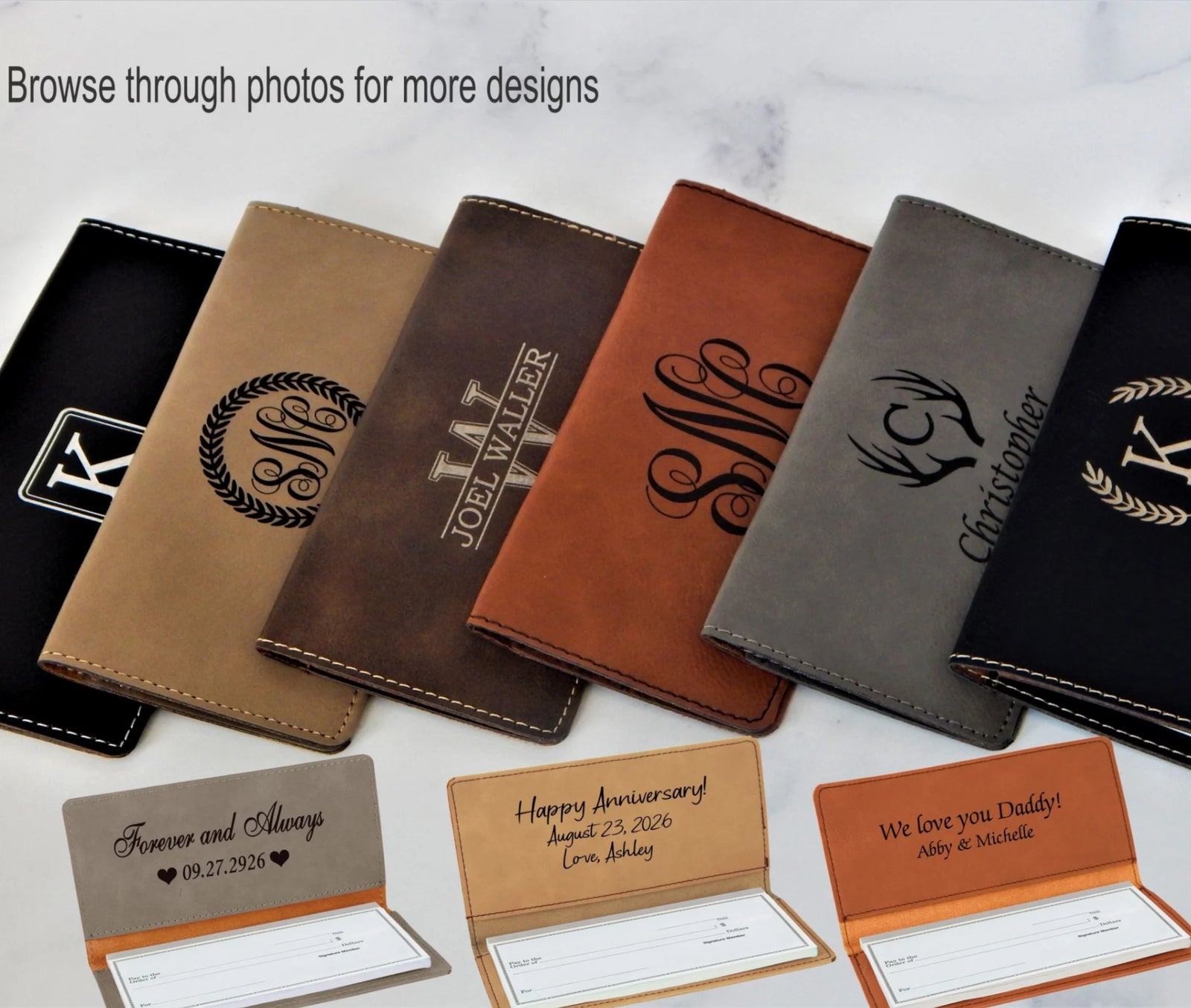 Six personalized leather checkbook holder mockups arranged in a fan shape on a light marble background, with three sample cards in front. The covers are in black, tan, dark brown, cognac brown, gray, and black, each featuring a different monogram or crest design.