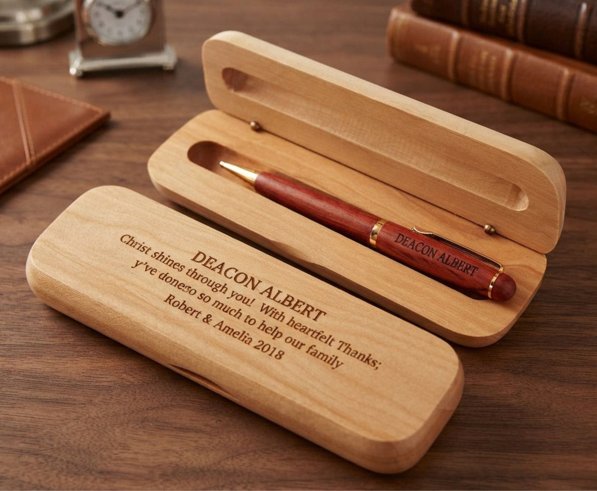 Personalized wooden pen case set on a wooden desk, with an open case holding a reddish-brown pen and a closed engraved case in front.