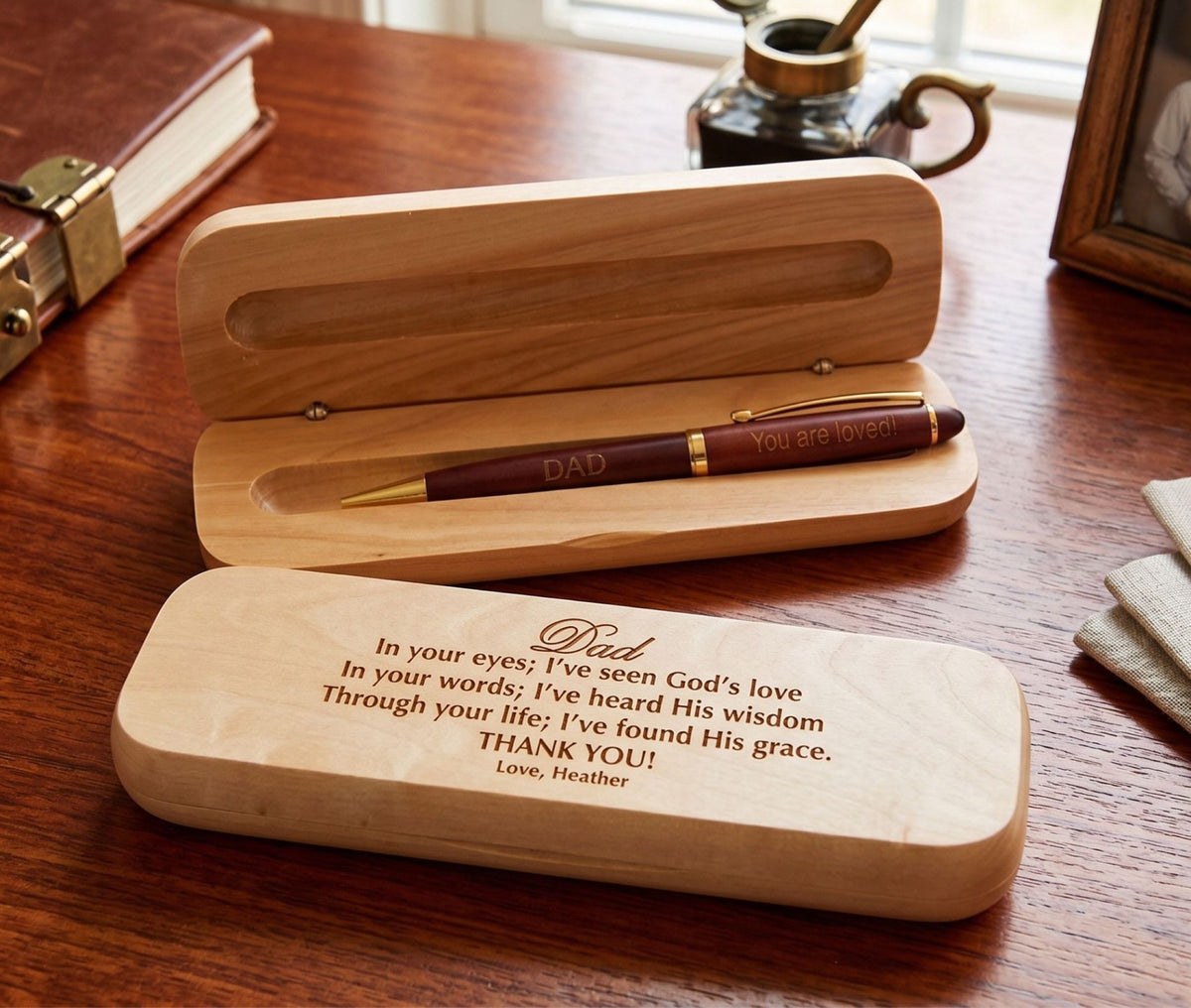 A personalized wooden pen gift box set on a wooden table, featuring an engraved wooden case with a message for Dad and a matching wooden tray holding a dark brown pen engraved with 'Dad You are loved'.