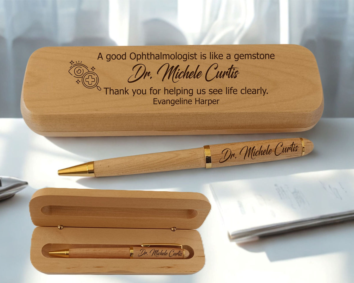 Personalized wooden gift set for an ophthalmologist, featuring a wooden case engraved with a thank you message and a matching wooden pen with gold accents, displayed on a white desk.