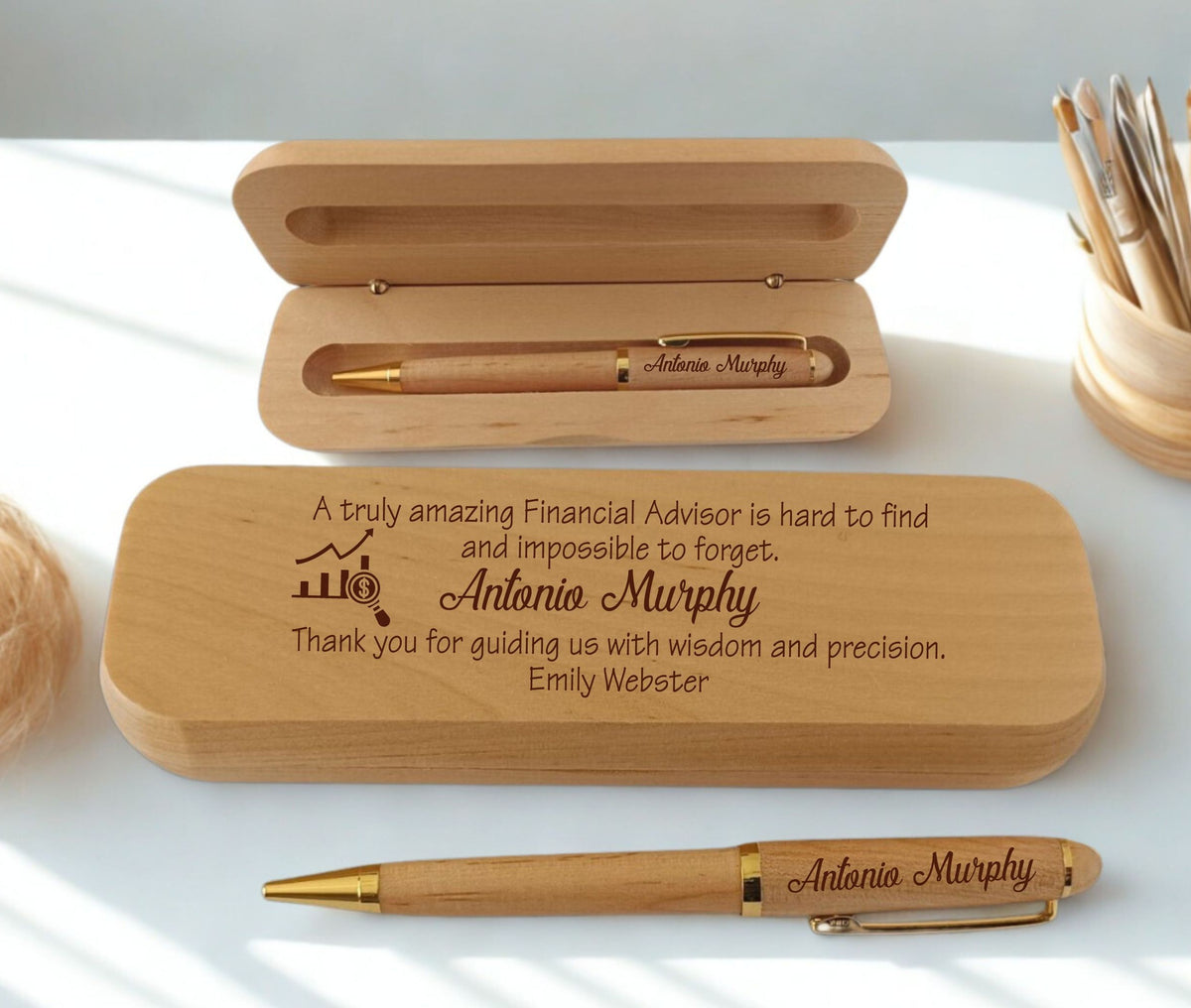 Personalized wooden pen and matching wooden case set on a white surface, with the case engraved with a thank-you message for a financial advisor named Antonio Murphy.
