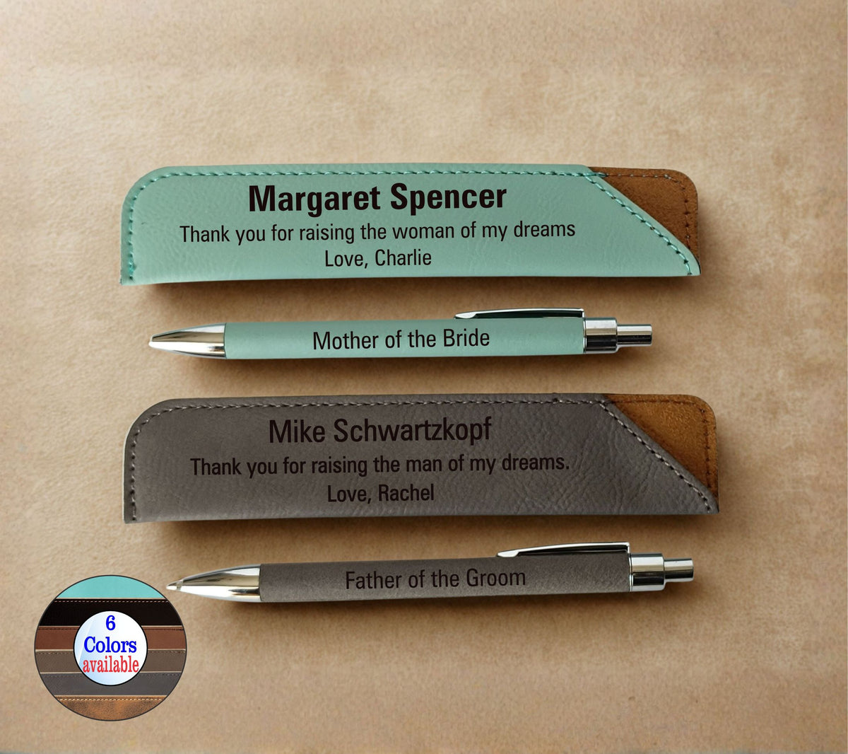 Two personalized metal pens with matching engraved leather pen sleeves on a beige background. One set is mint green with brown leather accents, and the other is dark gray with brown leather accents.