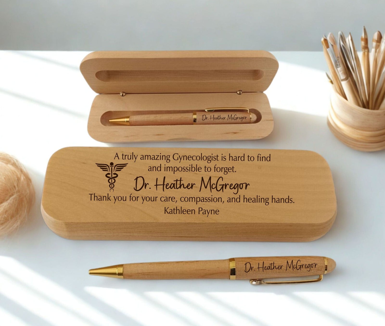 Personalized wooden keepsake box and pen set engraved with Dr. Heather McGregor, displayed on a white surface with soft natural shadows.