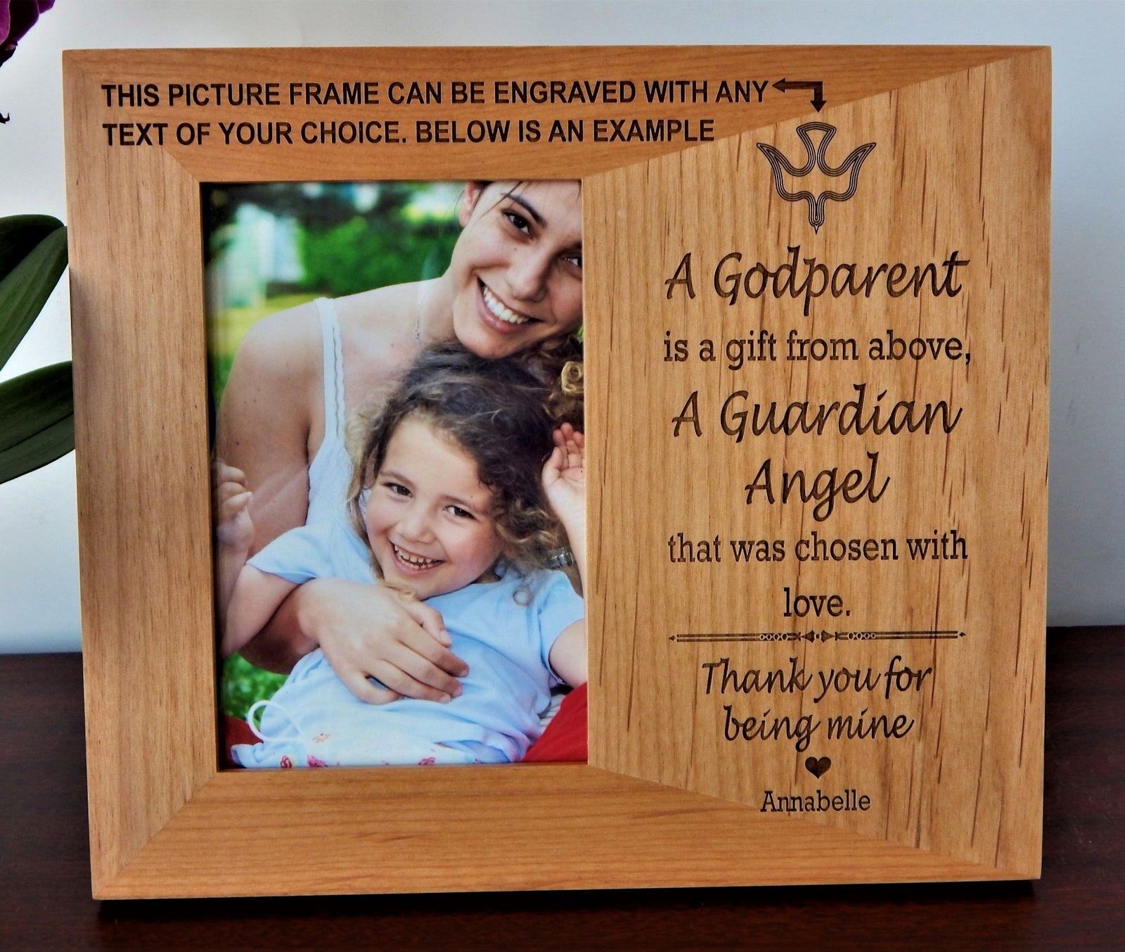 A personalized wooden photo frame with engraved text and a picture of a woman and child, displayed on a dark wooden surface against a light background.