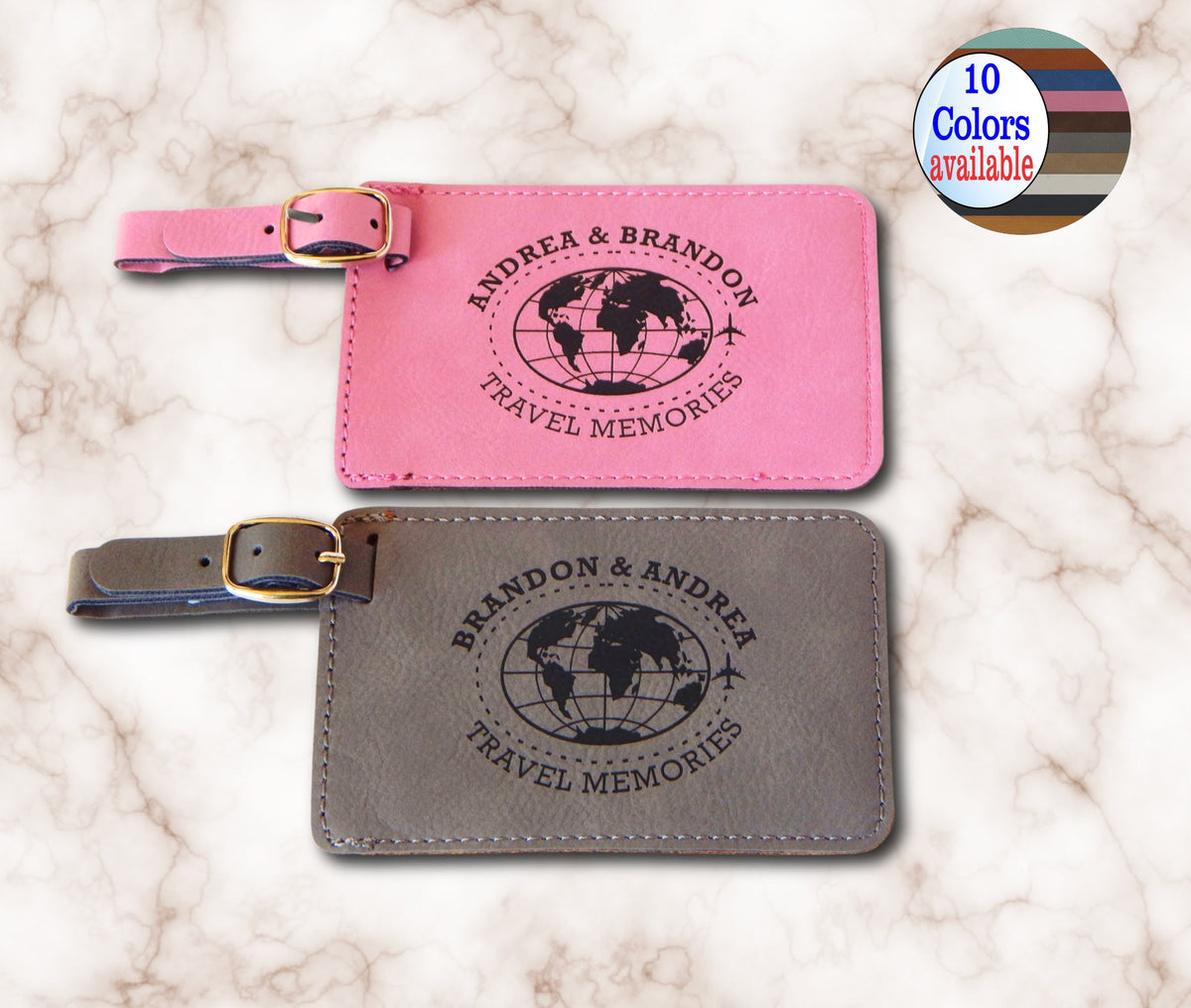 Two personalized leather luggage tags on a white marble background, one pink and one gray, both with black globe prints and the text 'BRANDON & ANDREA TRAVEL MEMORIES'. A circular badge in the top right says '10 Colors available'.