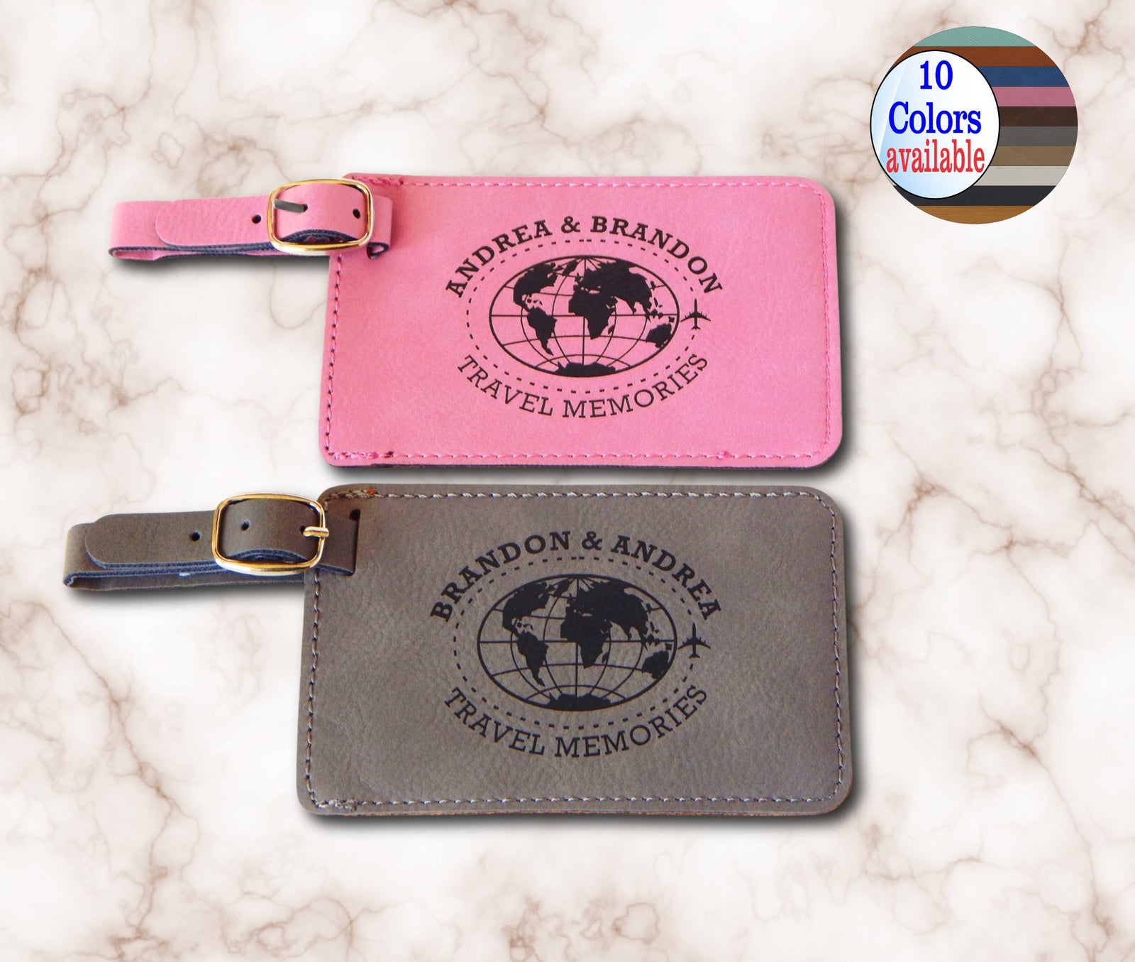 Two personalized leather luggage tags on a white marble background, one pink and one gray, both with black globe prints and the text 'BRANDON & ANDREA TRAVEL MEMORIES'. A circular badge in the top right says '10 Colors available'.