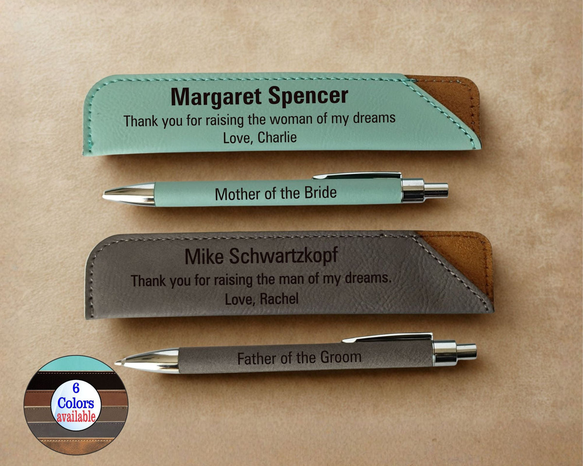 Two personalized metal pens with matching engraved leather pen sleeves on a beige background. One set is mint green with brown leather accents, and the other is dark gray with brown leather accents.