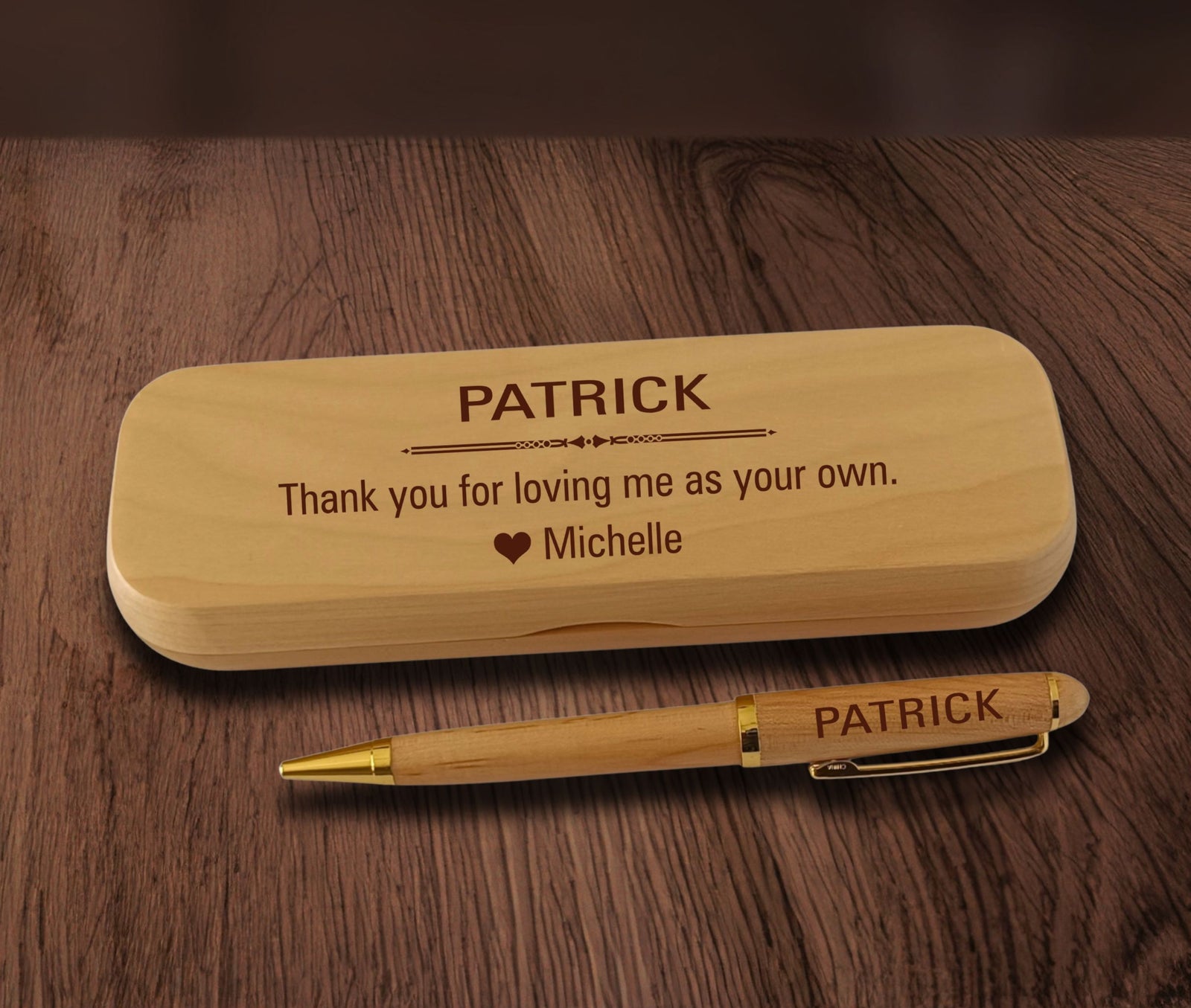 A personalized wooden pen and matching wooden case engraved with the name 'PATRICK' and a sentimental message, displayed on a dark wood background.