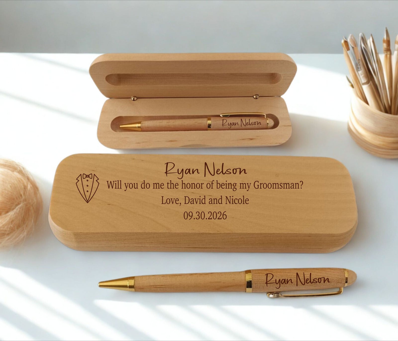 Personalized wooden pen gift set with engraved text on a white surface, including an open wooden case, a closed engraved case, and a matching wooden pen with gold-tone accents.