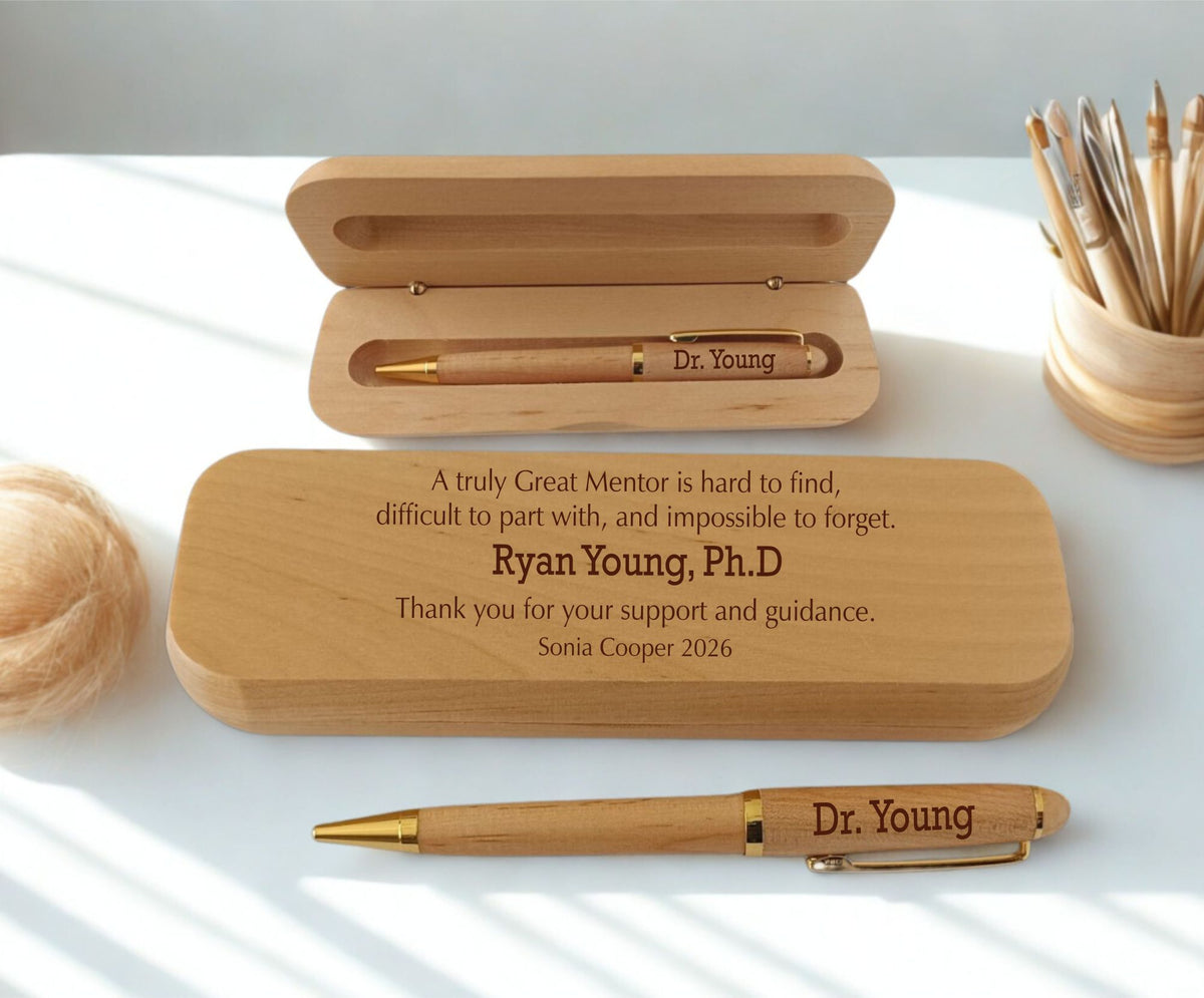 Personalized wooden pen case and matching pen set on a white surface with soft natural shadows. The open case shows a gold-toned pen, and the closed case in front has engraved memorial text for Ryan Young, Ph.