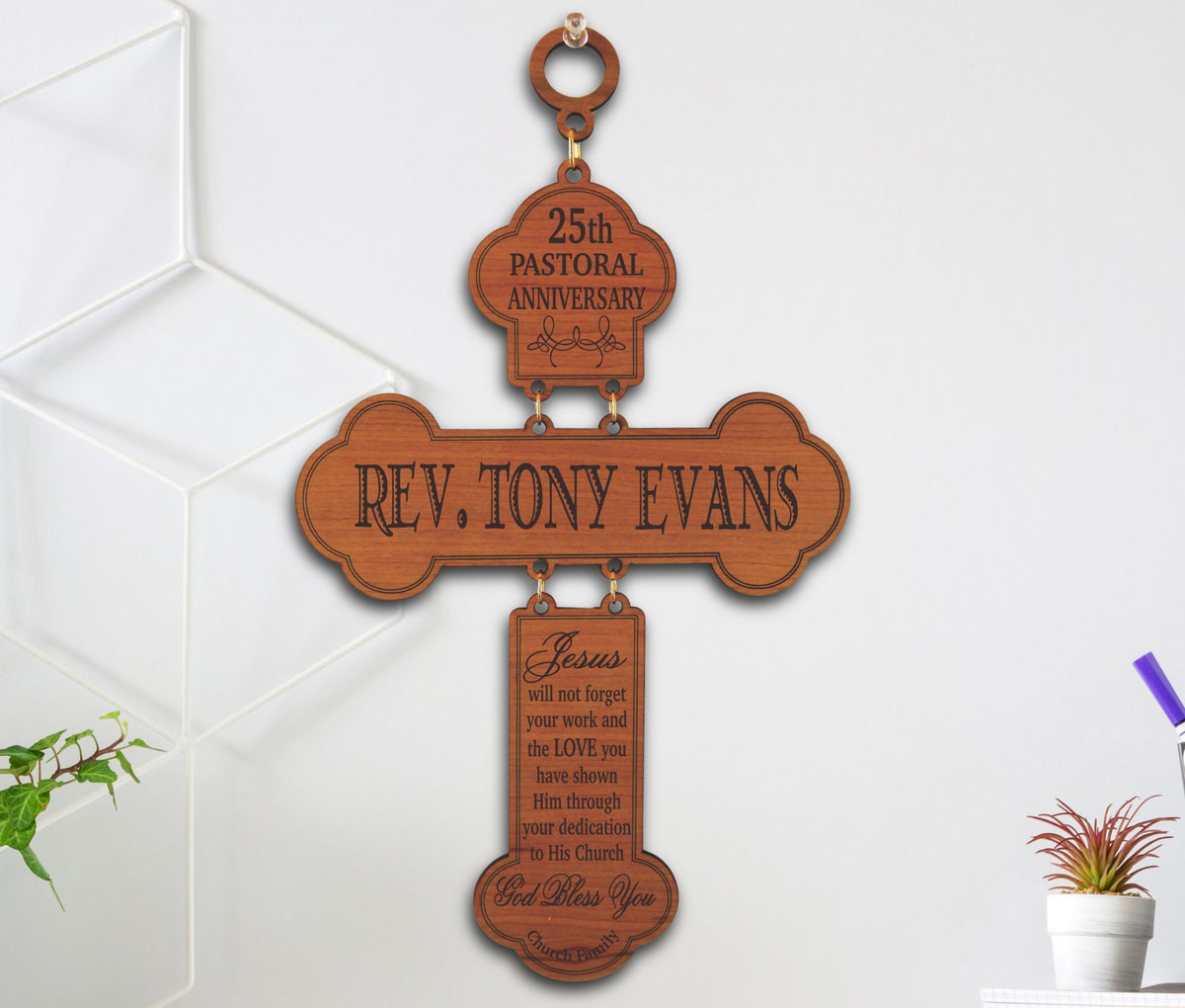 A wooden cross-shaped hanging plaque engraved with pastor appreciation message