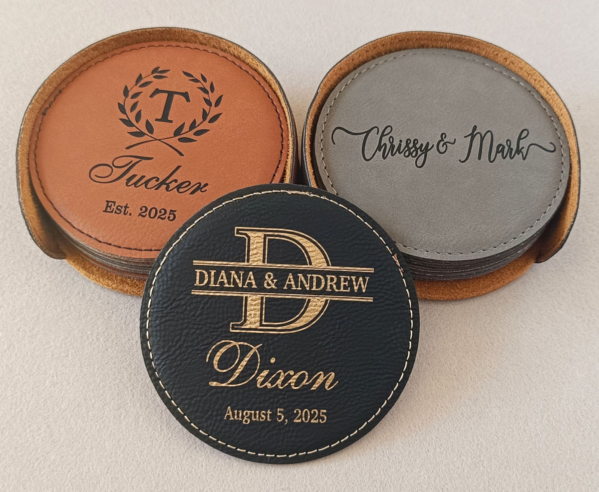 Three personalized round coasters displayed on a light beige background. One coaster is tan leather with black monogram and text, one is gray leather with black script, and one is black faux leather with gold monogram and text.