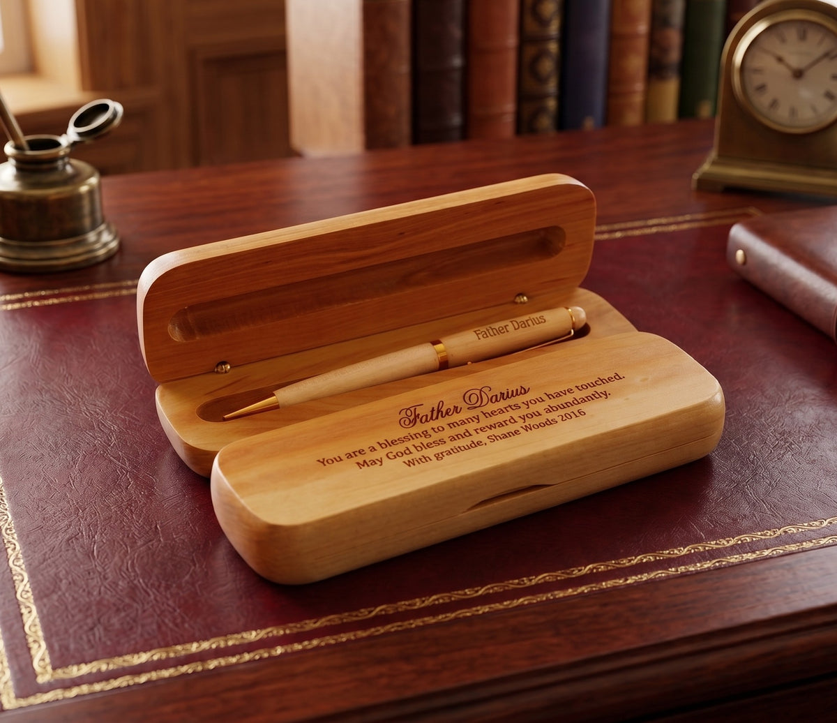 A personalized wooden pen gift set with an open wooden case on a dark wood desk. The set includes a light-colored wooden pen and a matching wooden case engraved with the name 'Brooke Davis' and a sentimental message.
