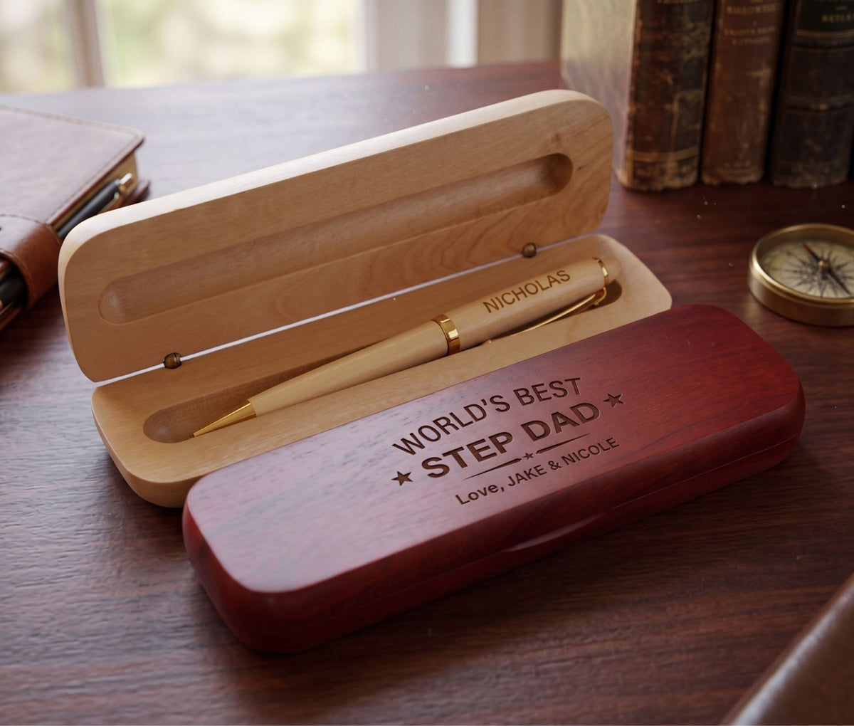 A set of personalized engraved wooden pen and case, with one pen placed in a case, showing an inscription on its side, and another pen placed outside the case, also with an inscription. 